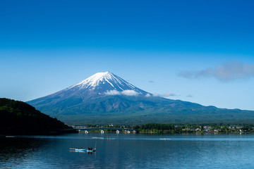 Fuji mountain and Kawaguchiko lake in morning, fog flow on the air and people do activity.