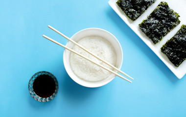 Rice bowl with Crispy Nori Seaweed on Blue background.Top view. Roasted sheets of seaweed.Asian healthy dry nori snack food. 