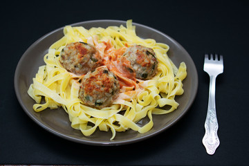 Pasta with meatballs on a dark background