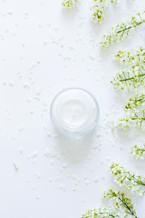 Daily  face cream.Organic natural cosmetic product .Jar with cream and flowers on white background. Woman's skincare routine. Beauty blogger flat lay concept.Place for your text or logo.