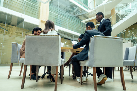 well-dressed business afro american men making a report to subordinate employees in a modern office