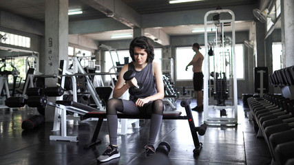 Sporty young women exercise by lifting dumbbells in the gym,  concept gym and bodybuilding.