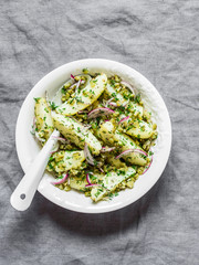 New potatoes, gherkins, red onions, french mustard olive oil dressing salad on a grey background,...