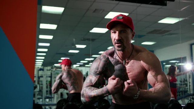 A handsome athletic male bodybuilder shows how he will demonstrate his muscles on the performance in the competition.