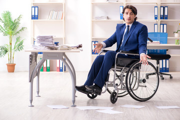 Young male employee in wheelchair working in the office 