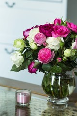 bouquet of fresh pink and white english roses flowers and cup of coffee on the glass table