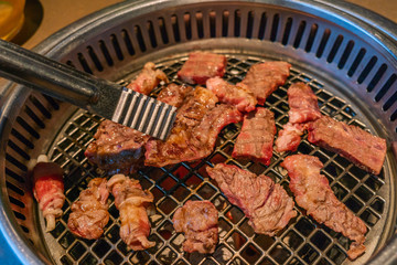 Closeup of marinated meat slices grilled on charcoal stove