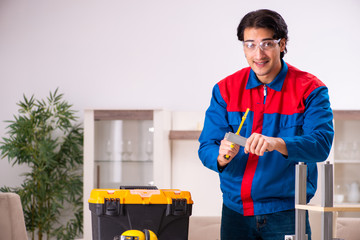 Young contractor repairing furniture at home 