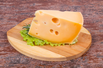 Maasdam cheese  in the board served salad leaves