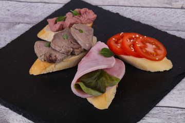 Bruschetta with tomato, ham and tongue