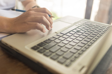 Close up of human hand tapping on laptop touchpad
