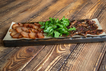 A meat plate on a wooden background.