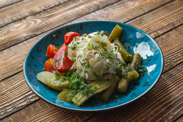 A bowl with pickles on a wooden background.