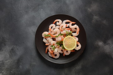 Fresh prawns. Raw shrimps, prawns in a plate on a dark background. Seafood. 
