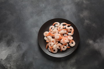 Fresh prawns. Raw shrimps, prawns in a plate on a dark background. Seafood.