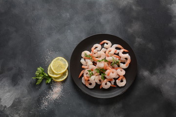 Fresh prawns. Raw shrimps, prawns in a plate on a dark background. Seafood.