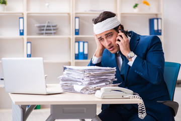 Head injured male employee working in the office 