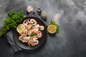 Fresh prawns. Raw shrimps, prawns in a plate on a dark background. Seafood.