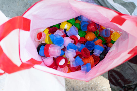 Recycling eco friedly concept background with sorted colorful plastic bottle caps in cellophone package