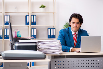 Young employee making copies at copying machine 