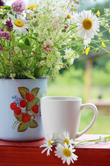 A cup of tea with daisies bouquet