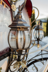 Fototapeta na wymiar Two wrought iron lantern near the window of the carriage