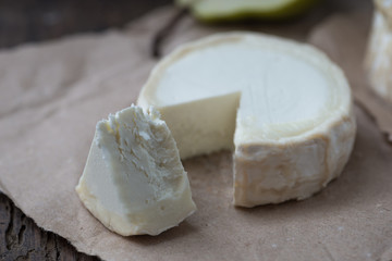 Piece smelly camembert cheese on a wooden rustic table