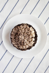 Homemade tiramisu cake on a white plate, top view. Flat lay, from above, overhead. Close-up.