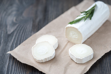 Fototapeta na wymiar Fresh goat cheese with slices on paper.