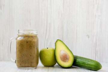 Cucumber apple avocado mint smoothie in a glass jar mug, side view. Closeup.