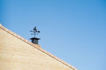 weather vane in the shape of a witch, on the roof