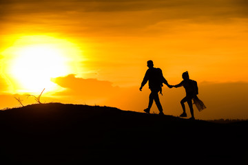Fototapeta na wymiar Silhouette couple on the mound in the sunset sky