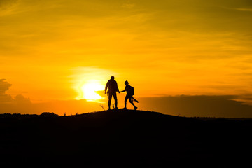 Silhouette couple on the mound in the sunset sky