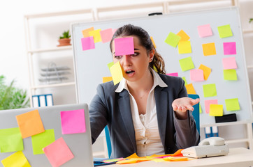 Young female employee in conflicting priorities concept 