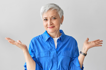 I have no idea. Stylish emotional middle aged mature female with short gray hair expressing...