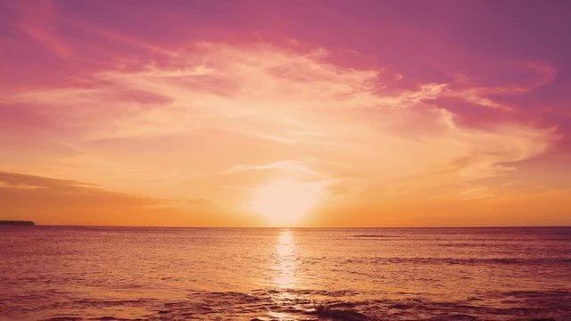 Red sunset over the sea. The sun touches the horizon. Red sky yellow sun and amazing sea. Summer seascape. Beautiful resort in the nice Atlantic Ocean. Spindrift clouds adorn the sunset sun. Fantastic