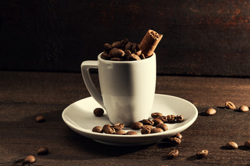 coffee cup of coffee beans with cinnamon on wooden background