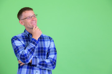 Portrait of happy hipster man with eyeglasses thinking