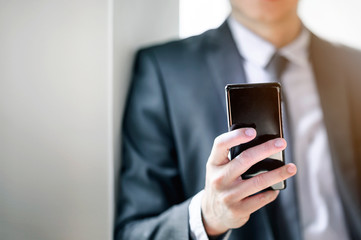 Closeup shot of businessman using smartphone at office.