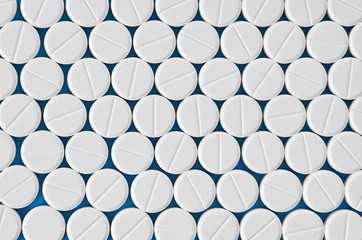 Pills tablets capsules closeup. On a blue background, a jar of medicine.