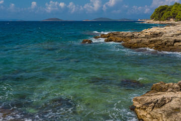 Fototapeta na wymiar Waves breaking on a stony beach in Murter, Croatia, Dalmatia