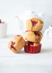 Freshly baked strawberry muffins on white background.