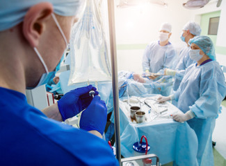 Arthroscope surgery. Orthopedic surgeons in teamwork in the operating room with modern arthroscopic...