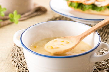 ほんのり湯気の立つ、スプーンですくったコーンクリームスープ