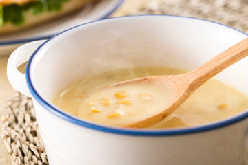 ほんのり湯気の立つ、スプーンですくったコーンクリームスープ