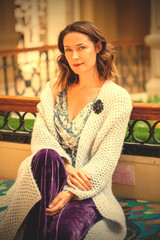 woman in a light knitted coat with a brooch