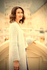 Beautiful middle-aged woman in a light knitted coat