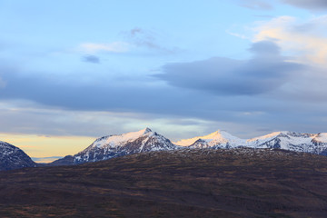 mountain summits at sunrise in norway in winter