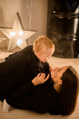 Cute cheerful child with mother play indoors.