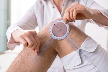Female doctor checking patient's joint flexibility with goniometer